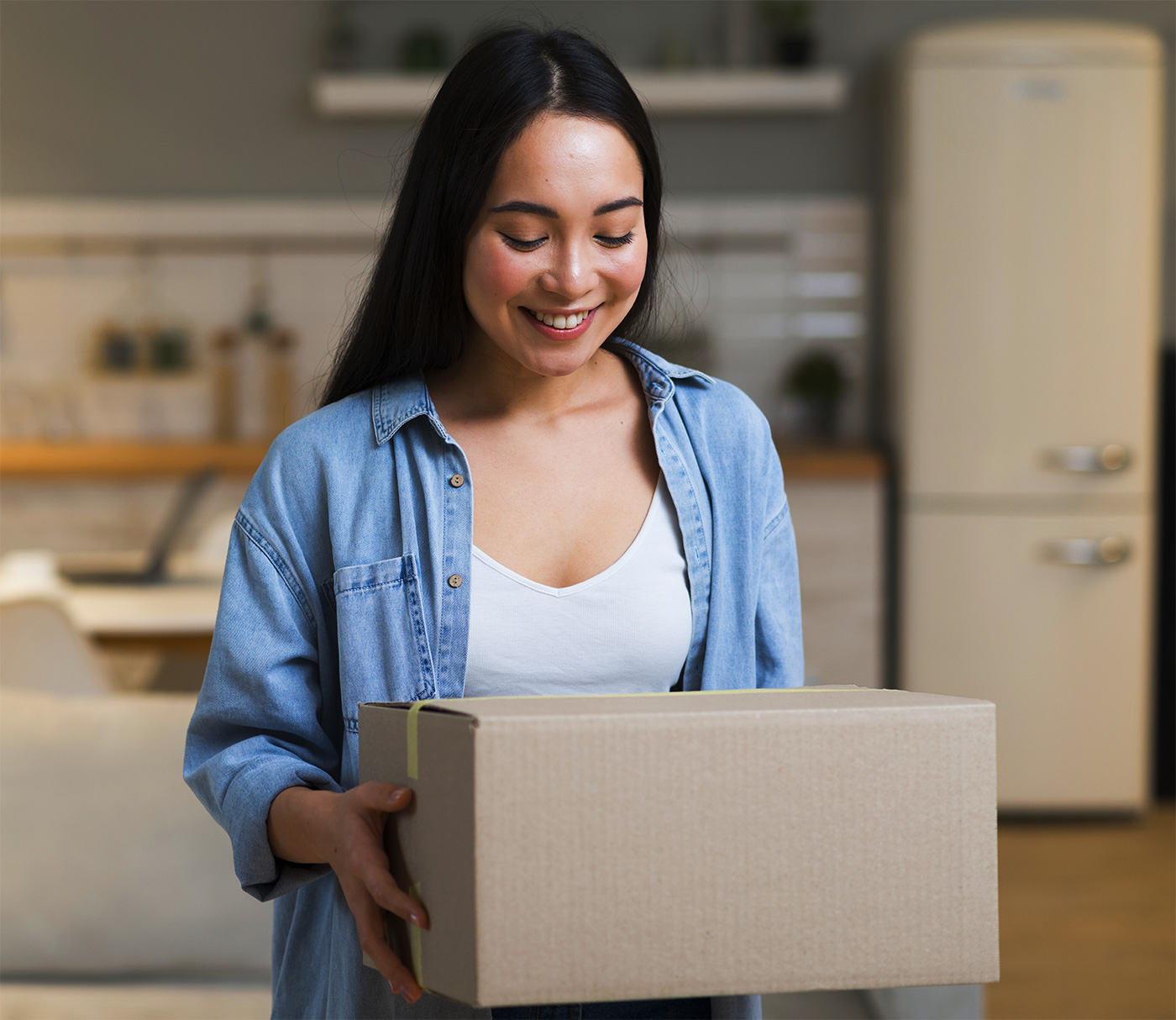 Mujer feliz que sostiene un paquete en mano